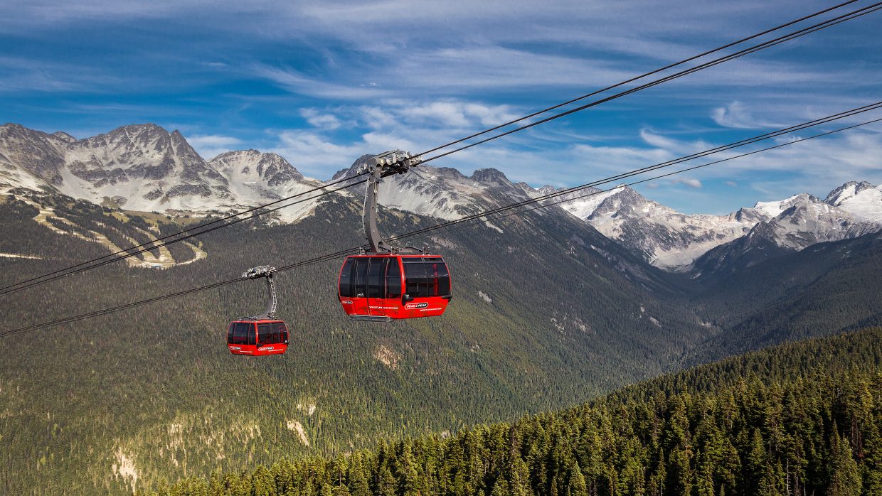 Les gondoles rouges de Whistler au-dessus de la vallée et des sommets enneigés