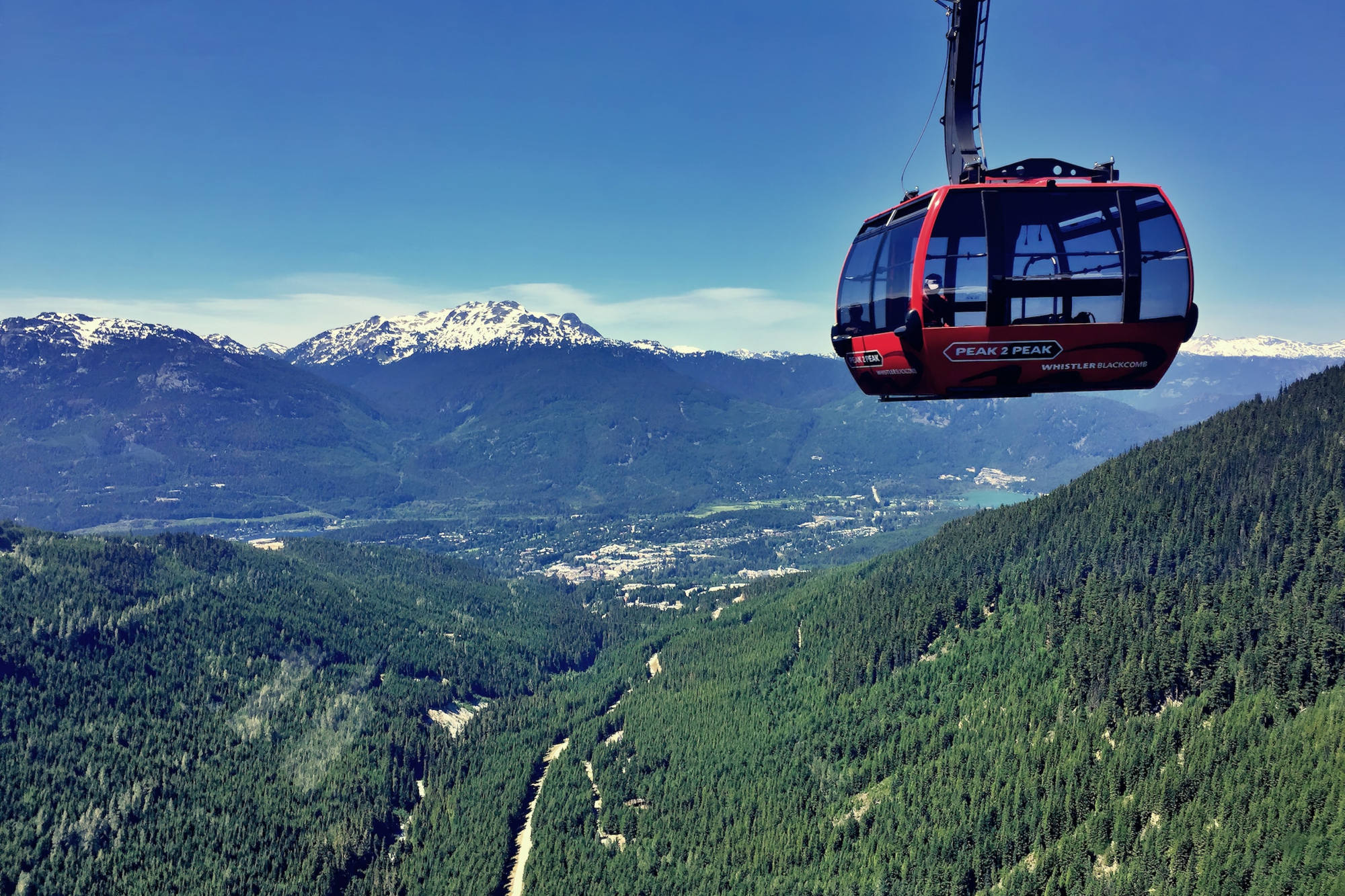 Une cabine rouge de la gondole Peak 2 Peak au-dessus de la vallée de Whistler