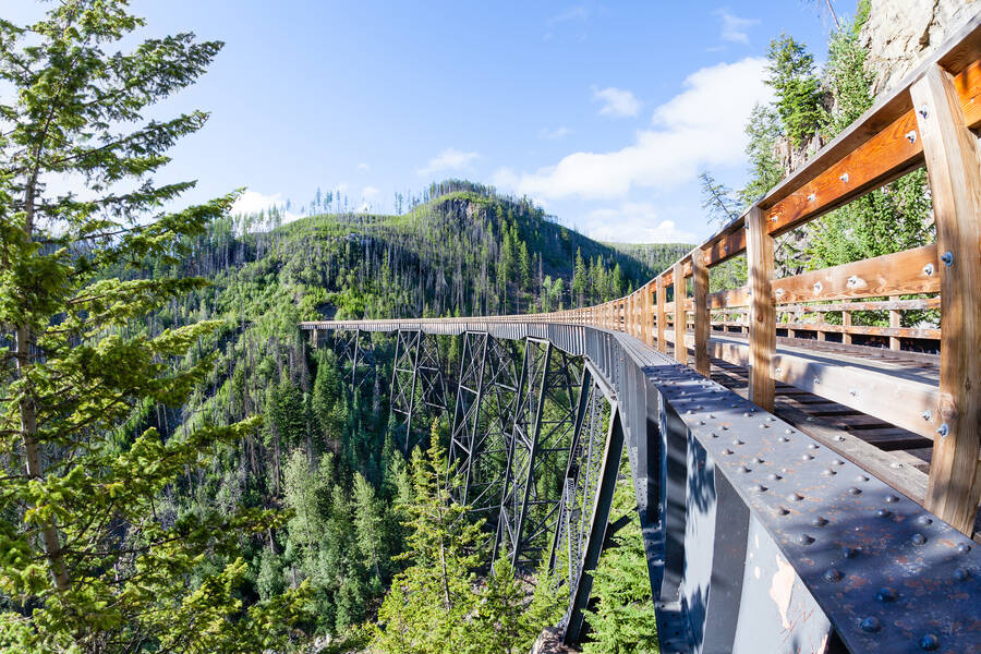 Une passerelle de bois de Myra Canyon au-dessus du canyon boisé