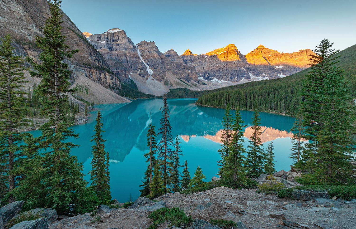 Le lac Moraine turquoise au lever du soleil, pics dorés derrière
