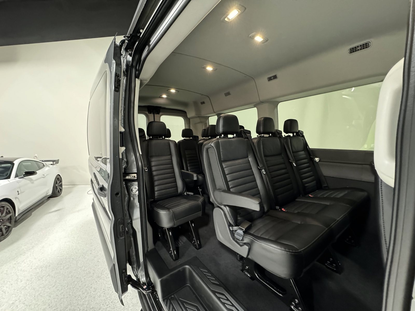 L’intérieur d’une Ford Transit 12 passagers vu par la porte coulissante ouverte